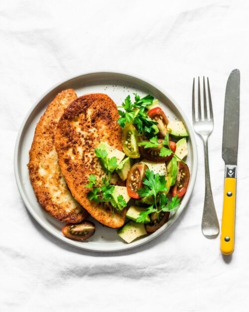 savory french toast on a white plate with greens and avocado 