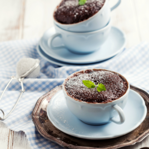 two chocolate cakes in blue mugs.