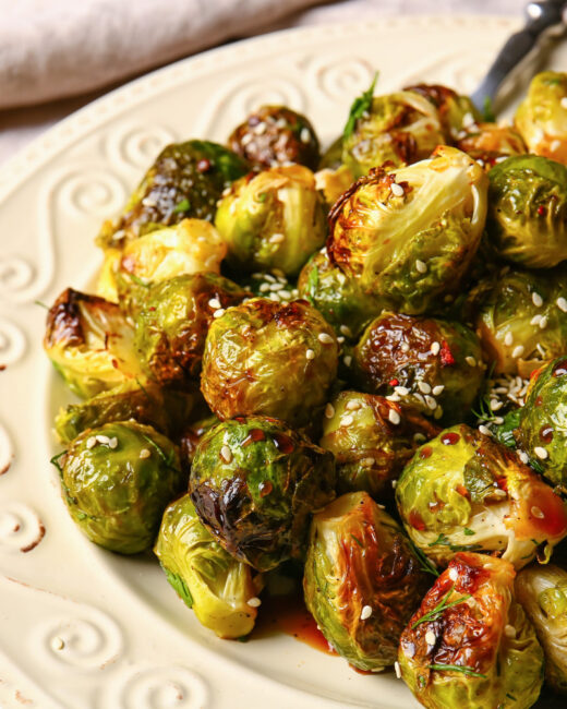 Sauteed Brussel Sprouts with Gochujang charred and on white plate 
