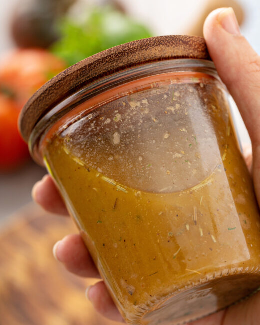 Smoky Sofrito Vinaigrette in mason jar and wooden lid in hand