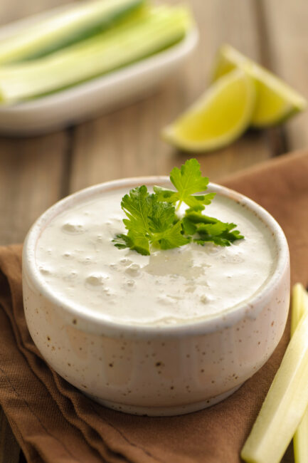 Blue Cheese Dressing in a small dish with fresh herbs and lime